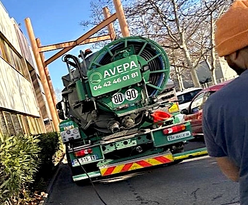 Camion d'assainissement garé sur une route urbaine.