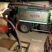 Technicien nettoyant égouts avec camion spécialisé.