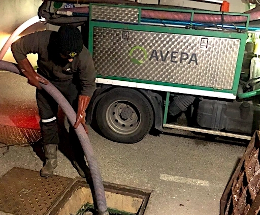 Technicien nettoyant égouts avec camion spécialisé.