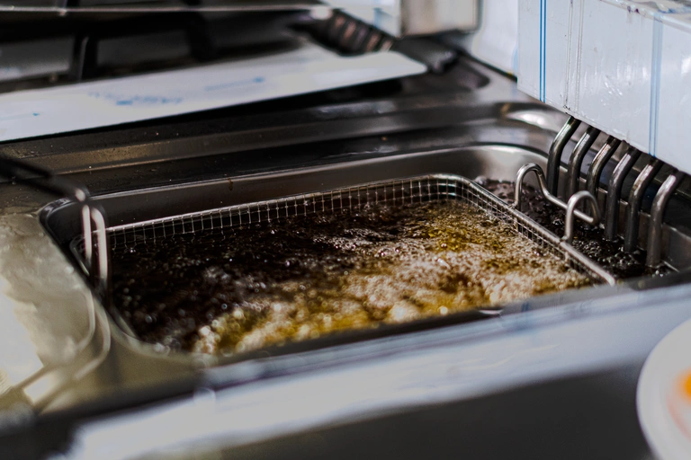 Friteuse professionnelle en fonctionnement dans une cuisine.