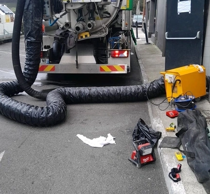 Camion d'entretien avec tuyaux et outils.